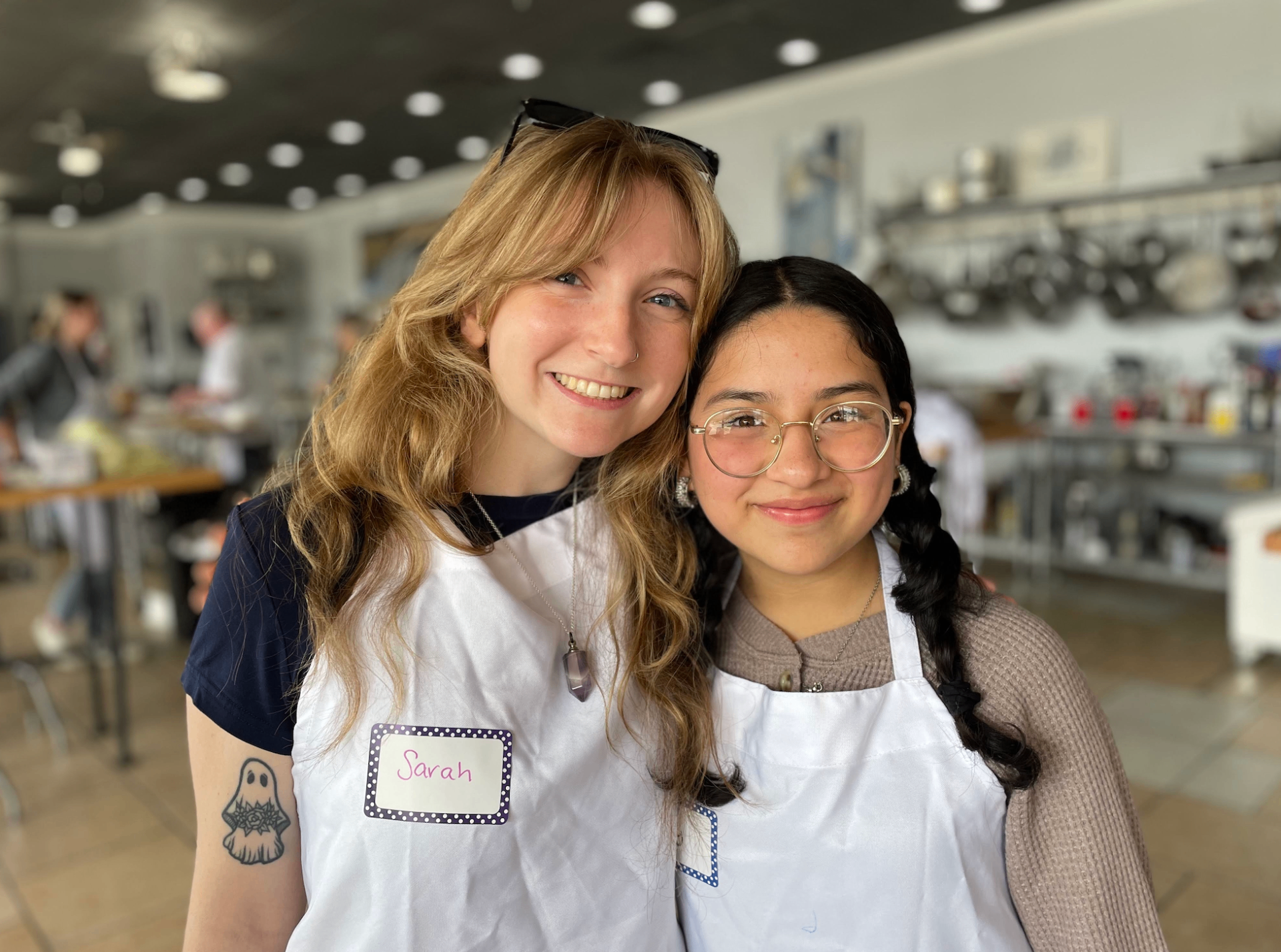A Sisters Circle mentor and mentee smiling together at a cooking class