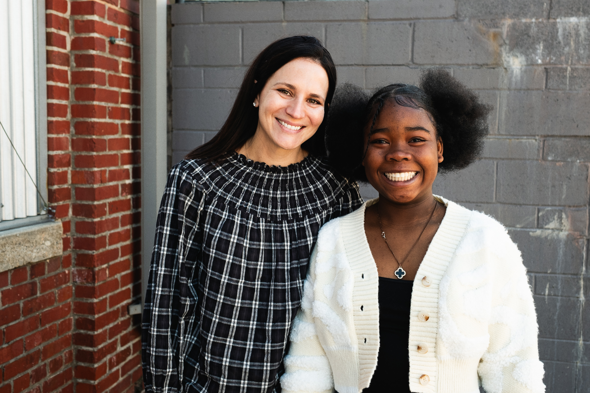 A mentor and her mentee smiling together