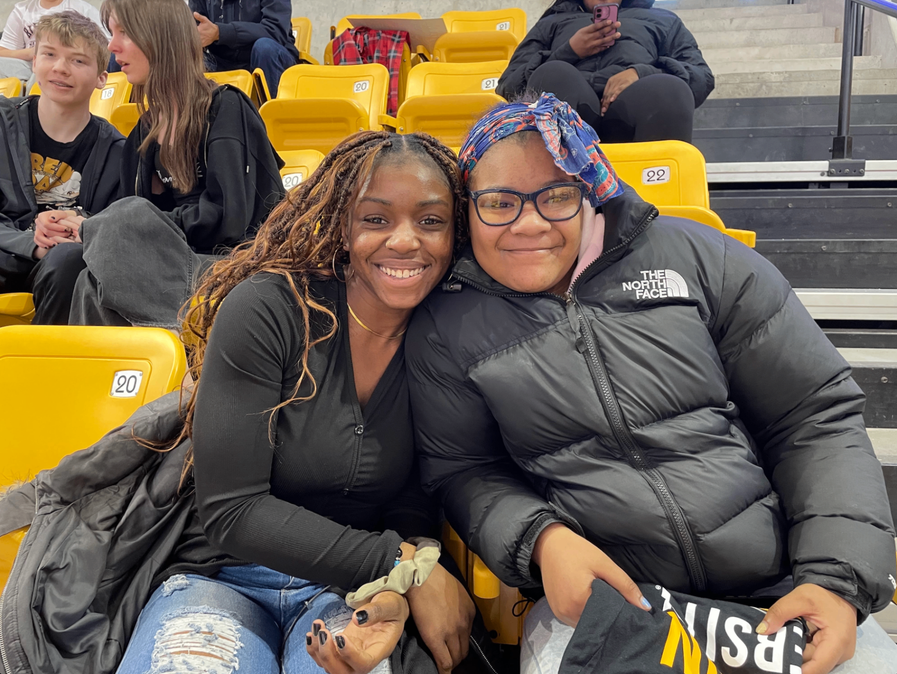 A mentor and mentee hugging at a basketball game
