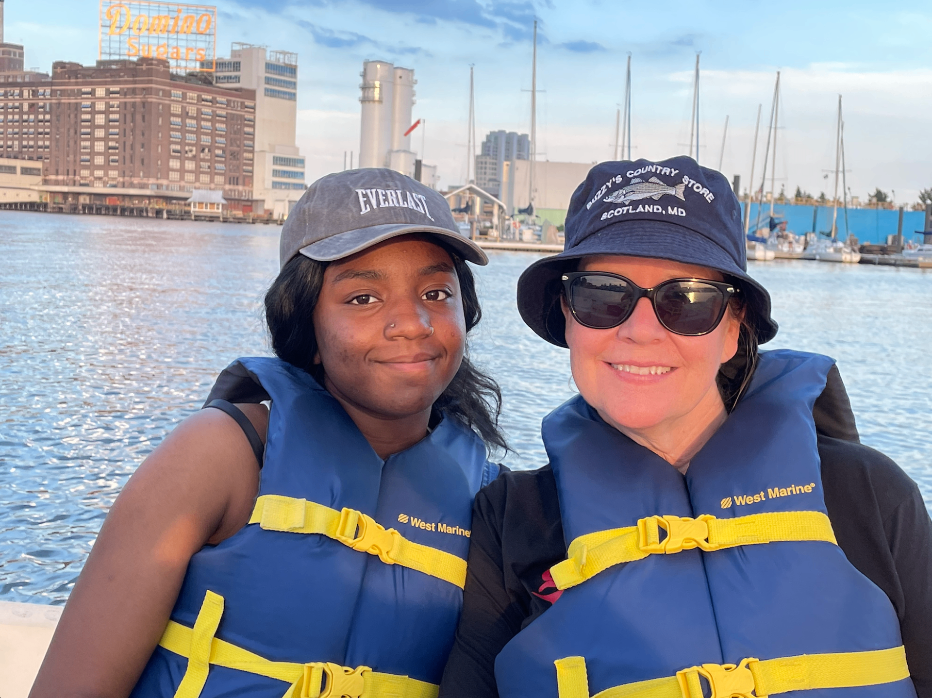 A mentor and mentee in blue life jackets on a boat in the Baltimore harbor